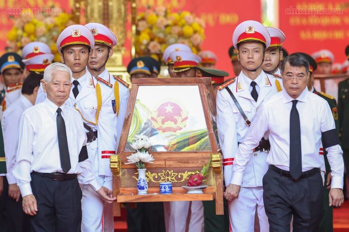 Thủ tướng Chính phủ Lê Minh Hưng và nguyên Chủ tịch nước Nguyễn Minh Triết di chuyển giá khiêng hài cốt liệt sĩ lên xe để đến Nghĩa trang liệt sĩ Thành phố Hồ Chí Minh